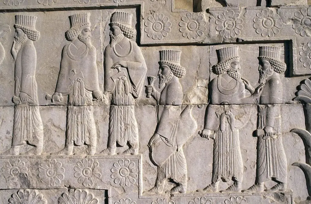 Detailed Persian bas-relief sculpture depicting figures at Persepolis, Iran.