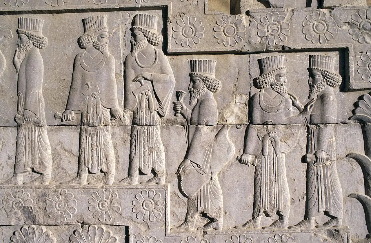 Detailed Persian bas-relief sculpture depicting figures at Persepolis, Iran.